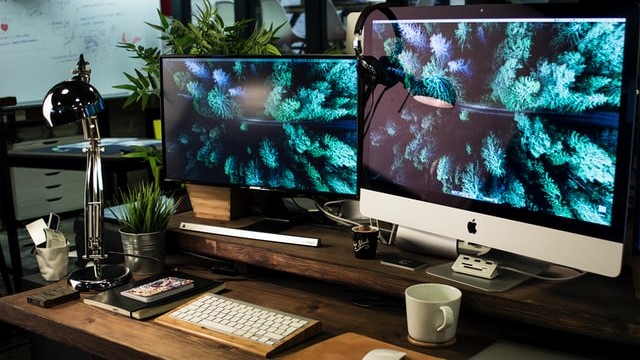 a colorful photo of a computer desk with two screens, very orderly and good looking work environment